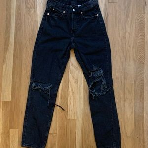 H&M straight leg black jeans with rips in the knees.